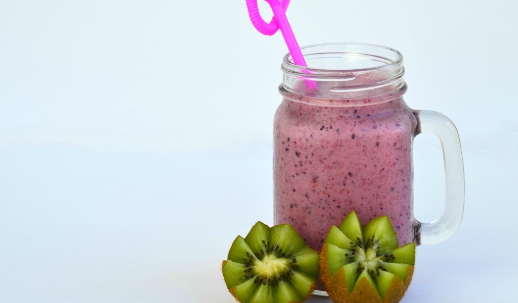 Розовый ягодный смузи на столе с киви