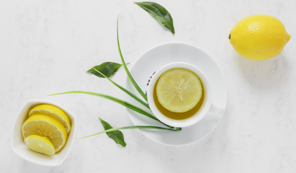 Чай в чашке на столе с кислым лимоном