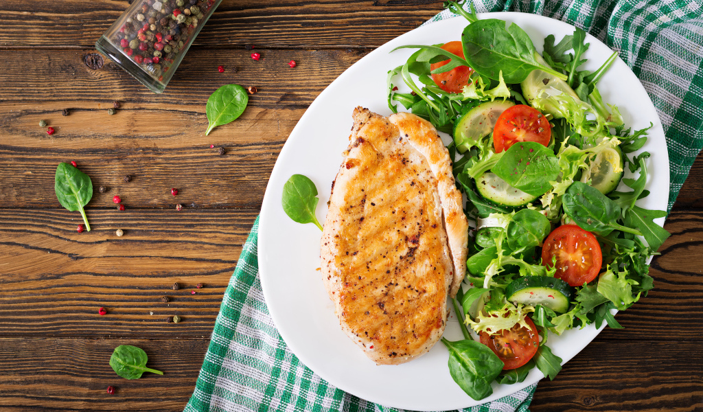 Жареная куриная грудка на тарелке с салатом