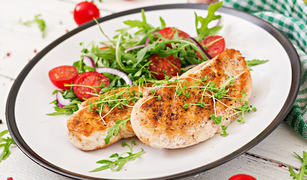 Жареная курица на тарелке с салатом