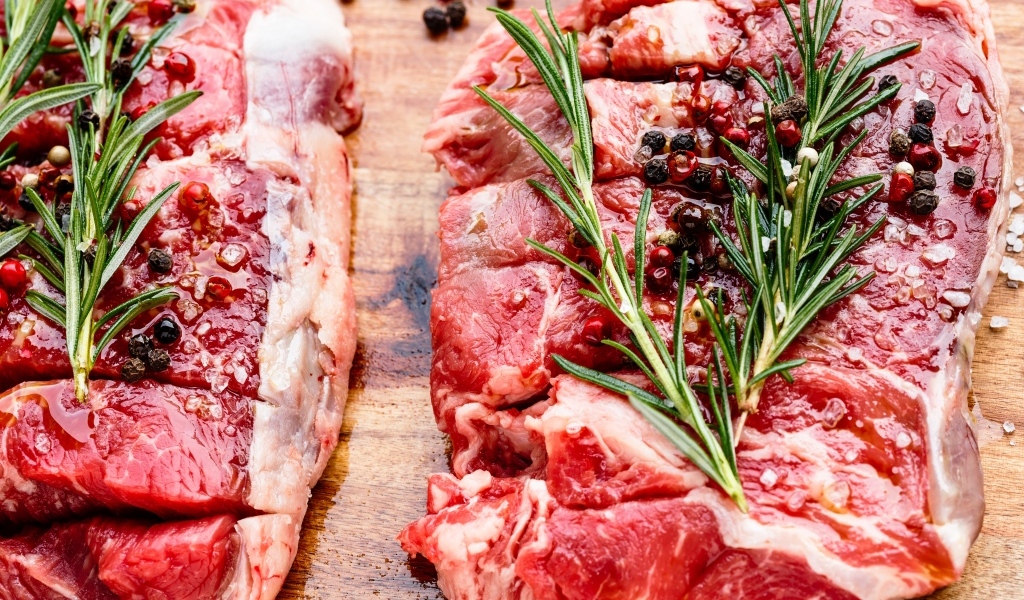 Кусок свежего мяса с перцем и розмарином