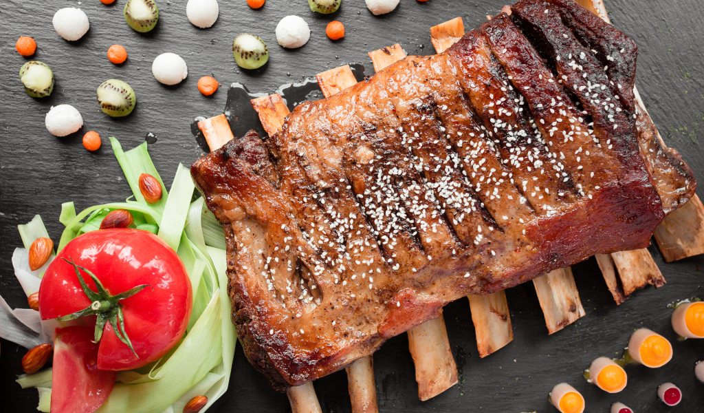 Свиные ребра на столе с овощами