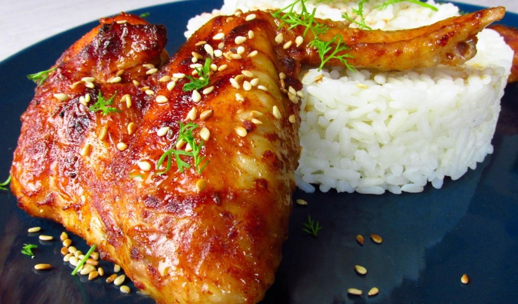 Рис на тарелке с жареным куриным крылом