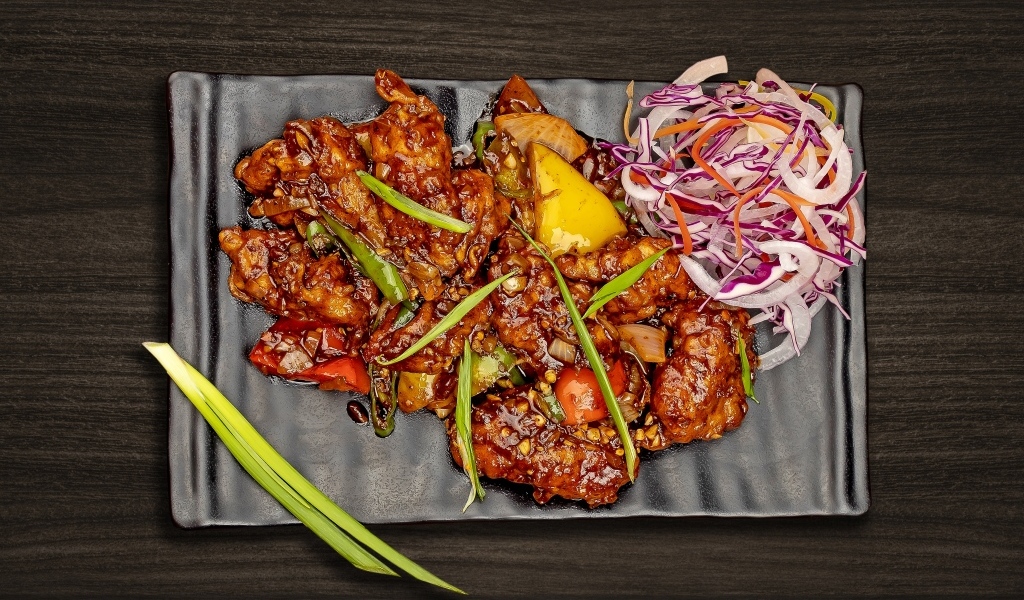 Острые куриные крылышки с салатом на тарелке