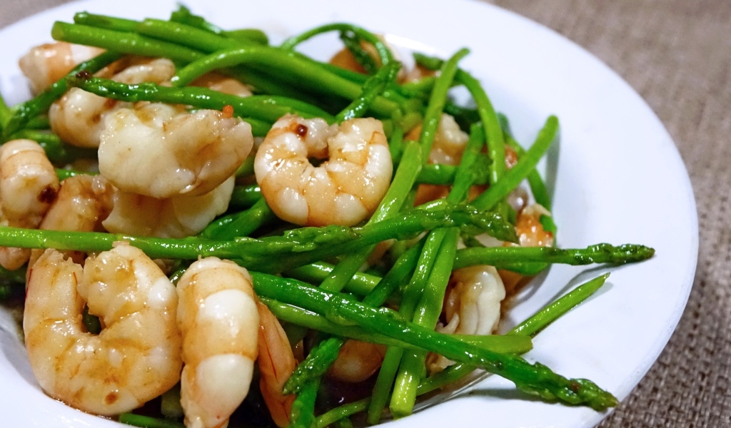 Спаржа с креветками в белой тарелке