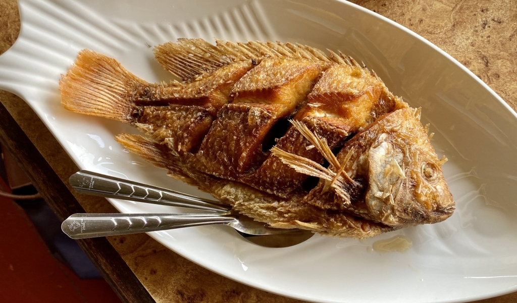 Запеченный карп на белой тарелке