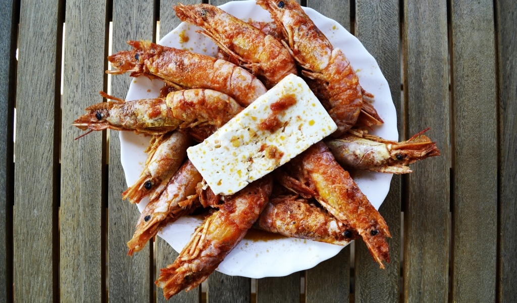 Жареные креветки на тарелке с сыром