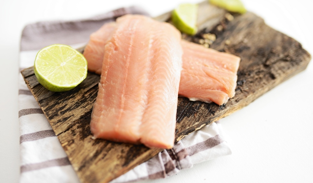 Кусочки рыбы на столе с лаймом