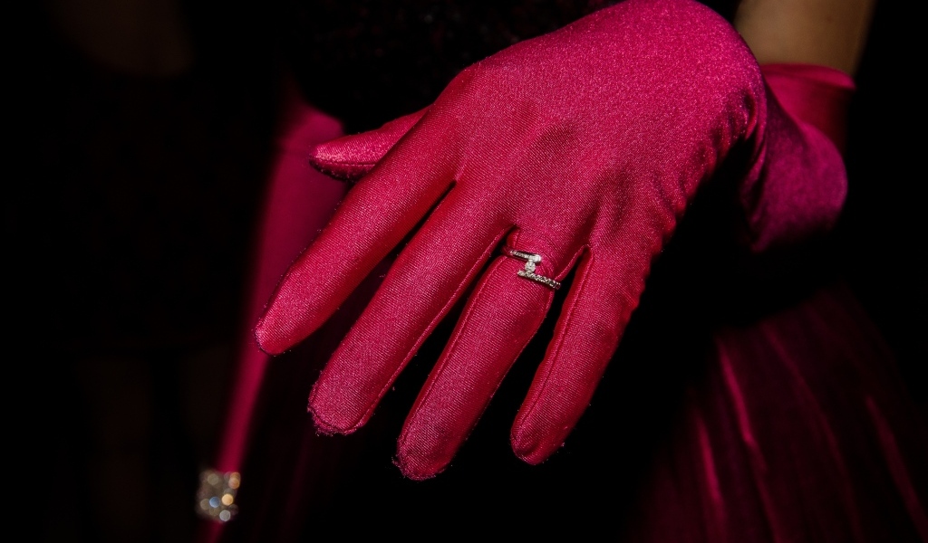 Женская рука с красной перчаткой и кольцом