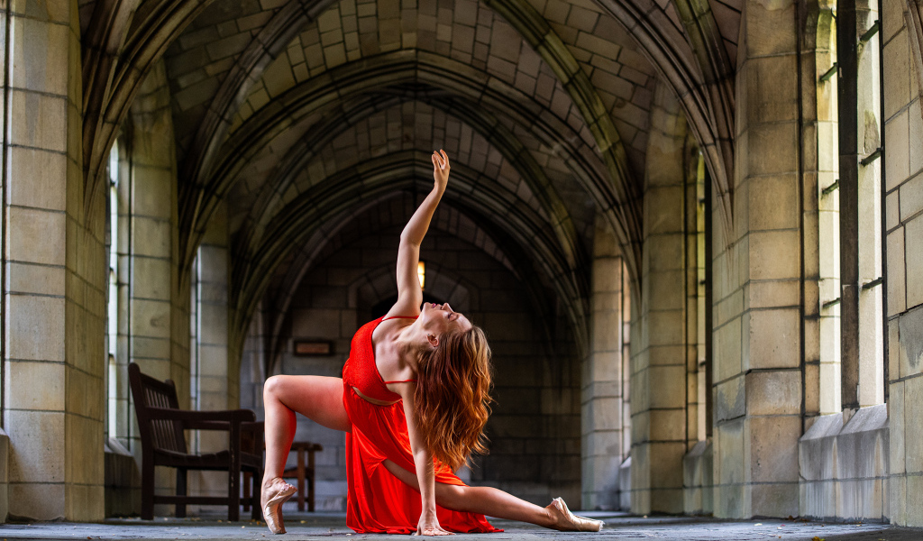 Девушка в красном наряде танцует в здании