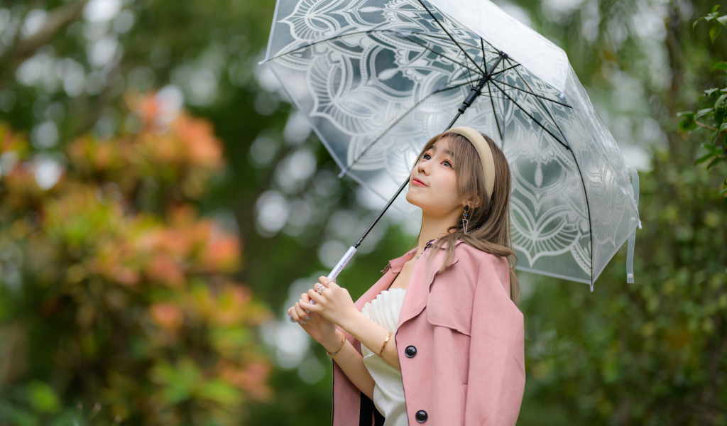 Девушка азиатка в пальто под прозрачным зонтом