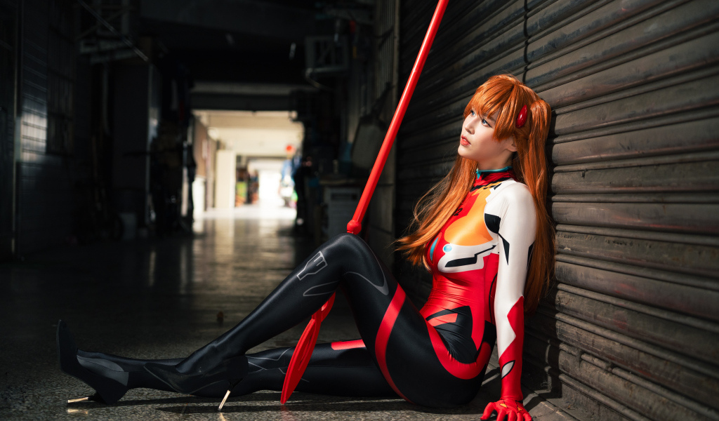 Девушка азиатка в костюме сидит у стены