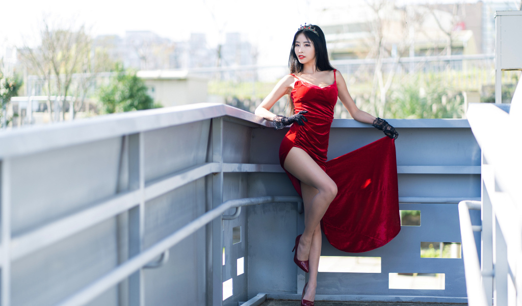 Азиатка в красном платье с короной на голове