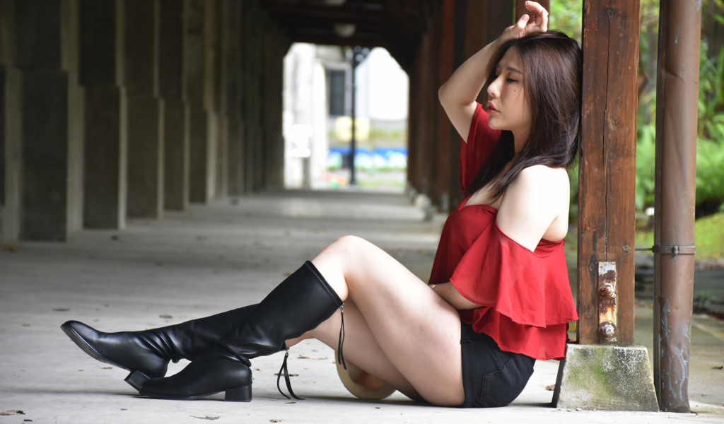 Азиатка с закрытыми глазами в черных сапогах