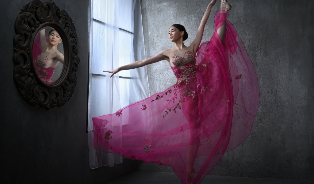 Девушка балерина в красивом розовом платье у окна