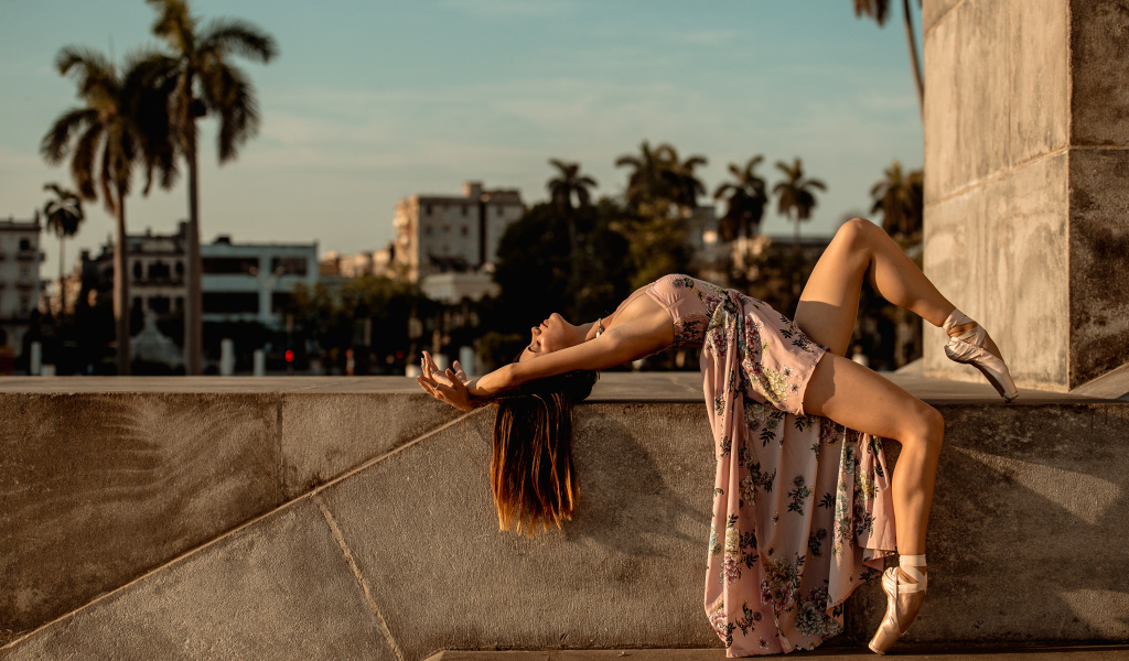 Девушка балерина в платье греется на солнце