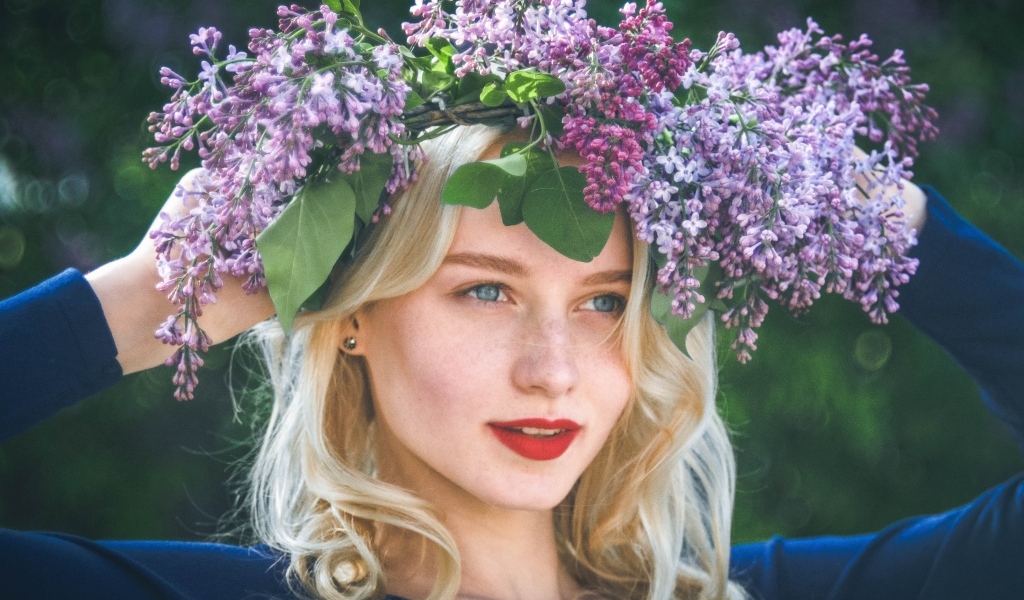 Красивая голубоглазая девушка с венком из сирени на голове