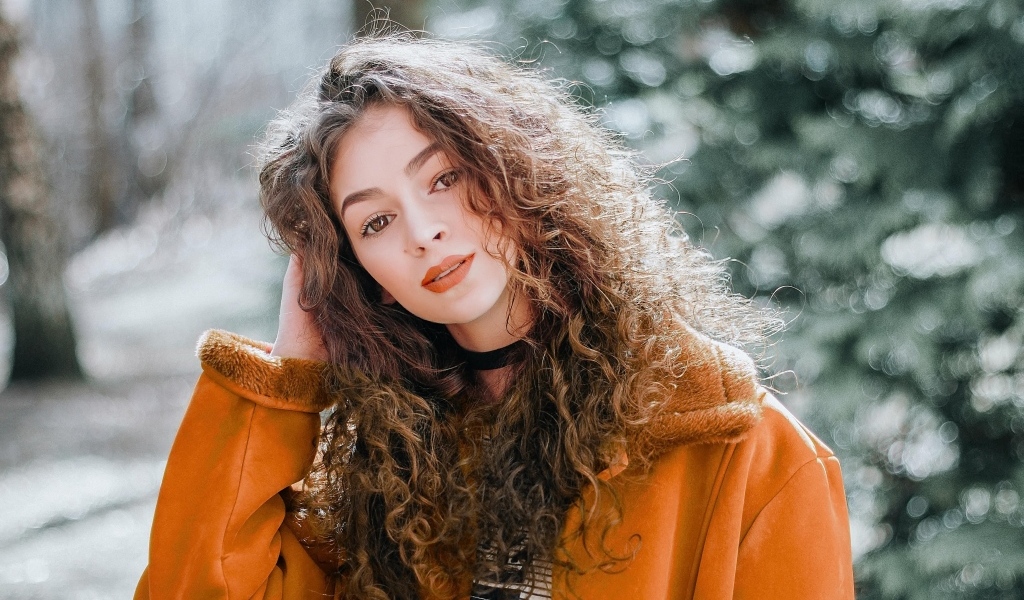 Красивая девушка с кудрявыми волосами и карими глазами