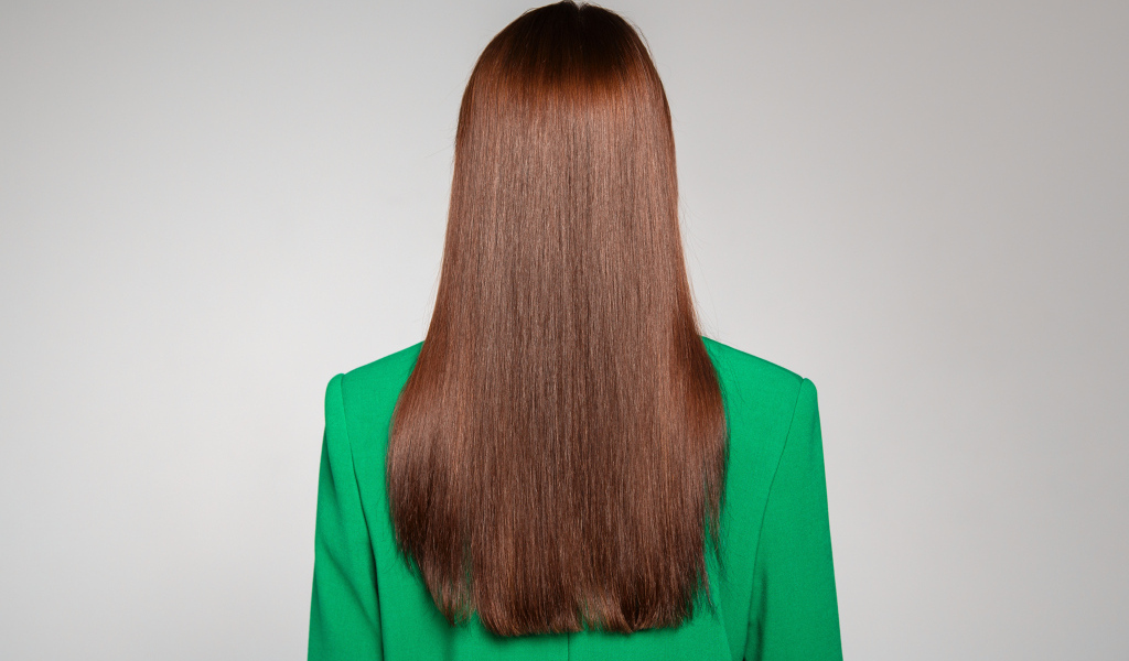 Красивые волосы девушки в зеленом пиджаке