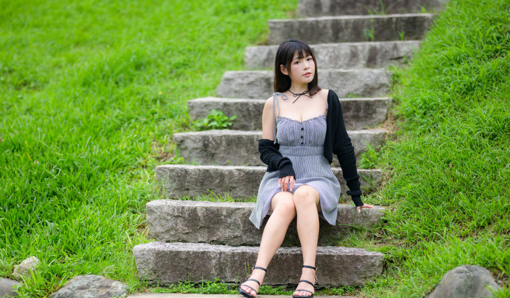 Красивая молодая девушка азиатка сидит на ступеньках