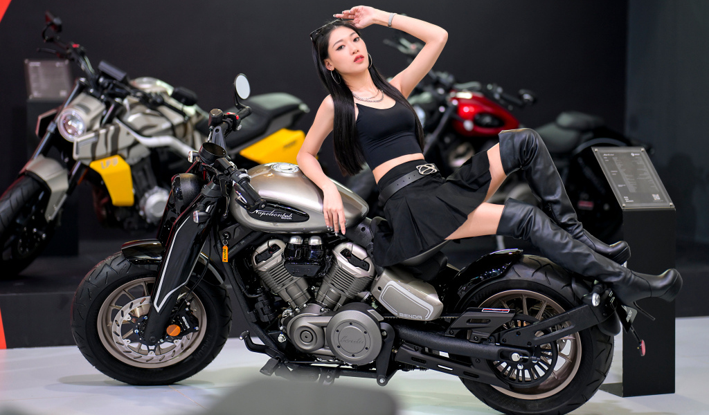 Брюнетка азиатка лежит на мотоцикле