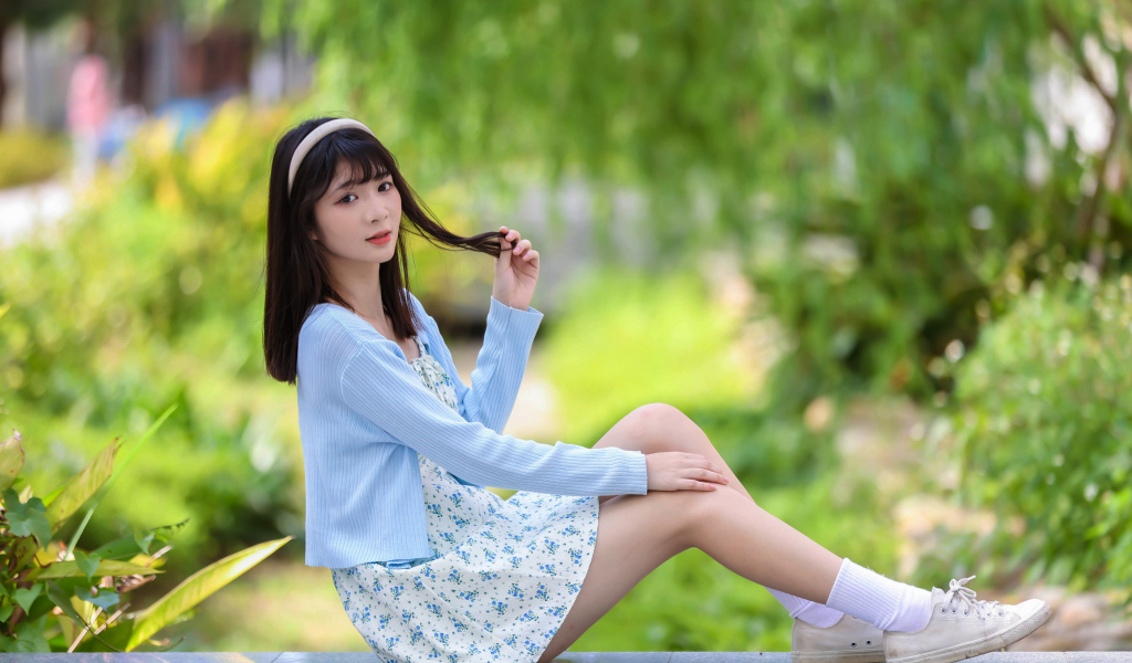 Милая азиатка в голубой кофте и в платье