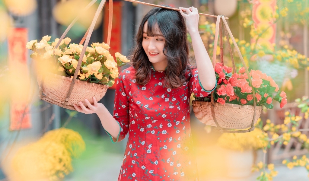 Милая девушка азиатка с цветами в красном платье