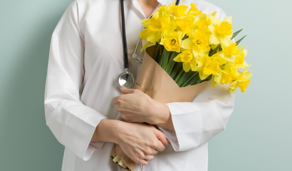 Доктор в букетом нарциссов  в руках