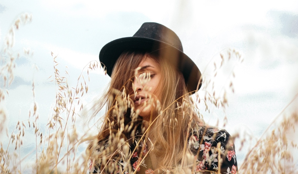 Девушка в черной шляпе в траве