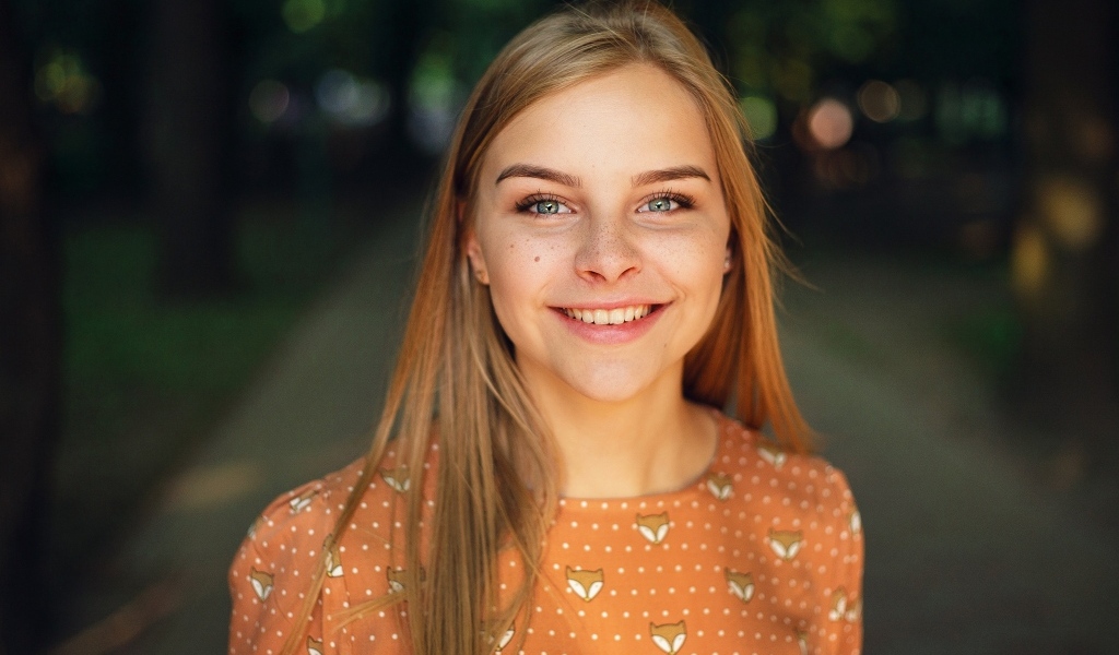 Улыбающаяся милая зеленоглазая девушка