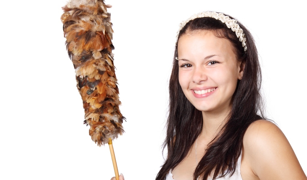 Улыбающаяся девушка убирается в комнате