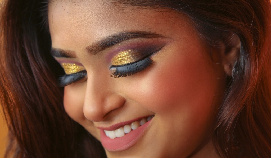 Улыбающаяся девушка с макияжем на глазах