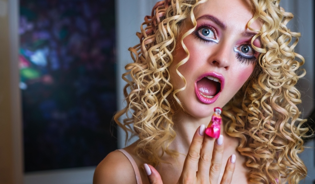 Удивленная девушка блондинка с макияжем куклы