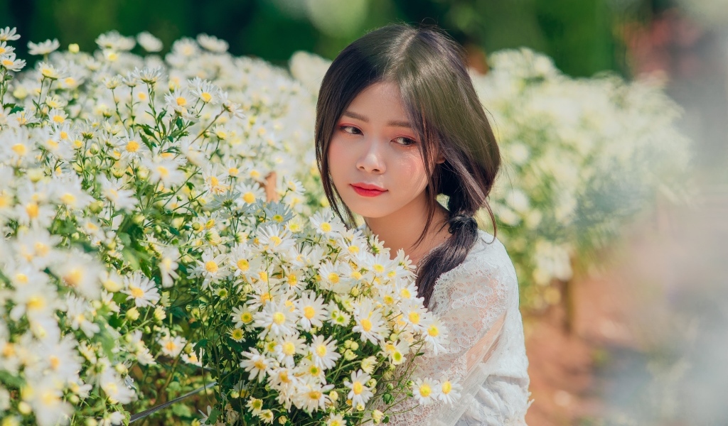 Нежная девушка азиатка с цветами ромашки