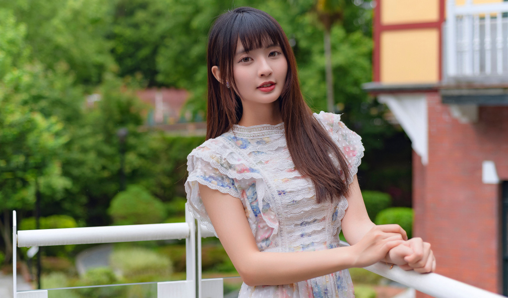 Нежный взгляд молодой длинноволосой азиатки в платье