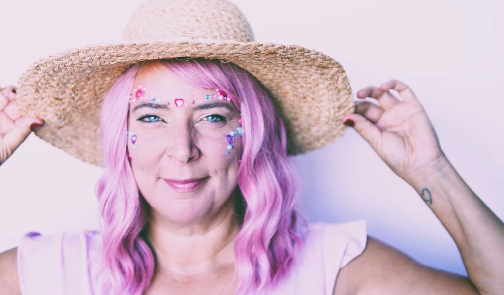 Женщина в шляпе с розовыми волосами