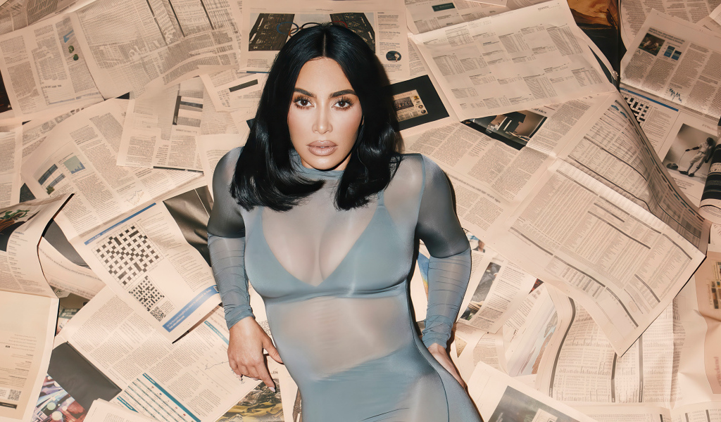 Модель Ким Кардашьян лежит на полу на газетах