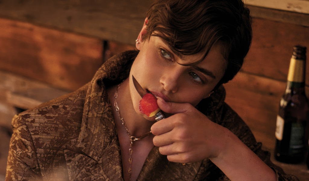 Модель Тейлор Хилл с ножом ест яблоко