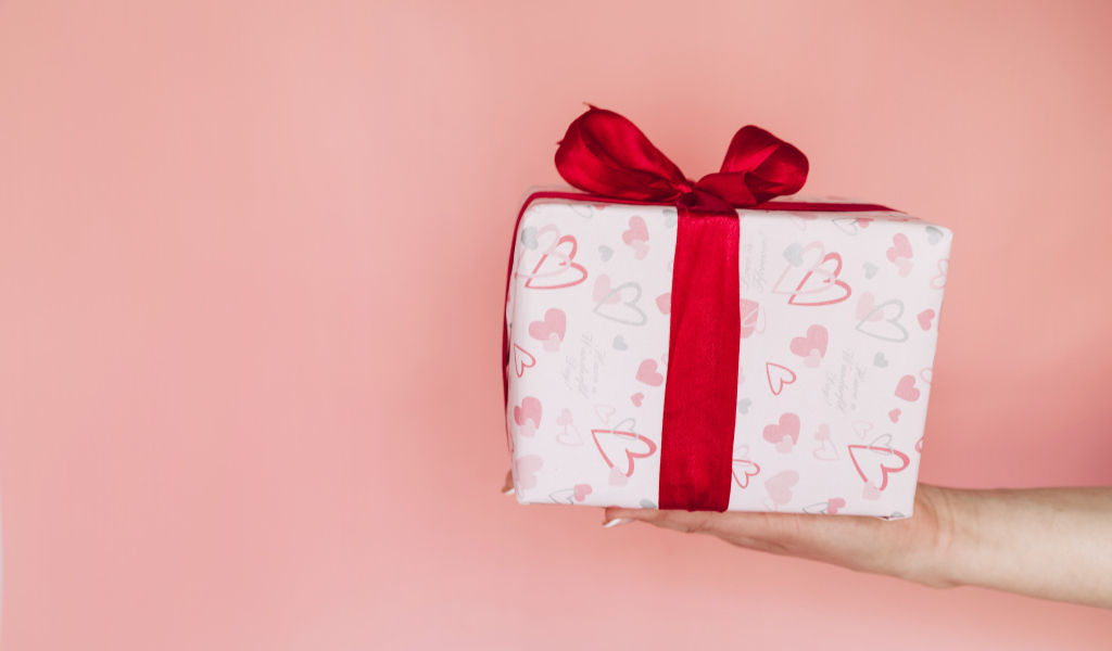 Девушка держит коробку с подарком