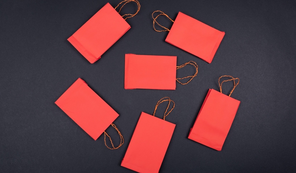 Красные пакетики для подарков на черном столе