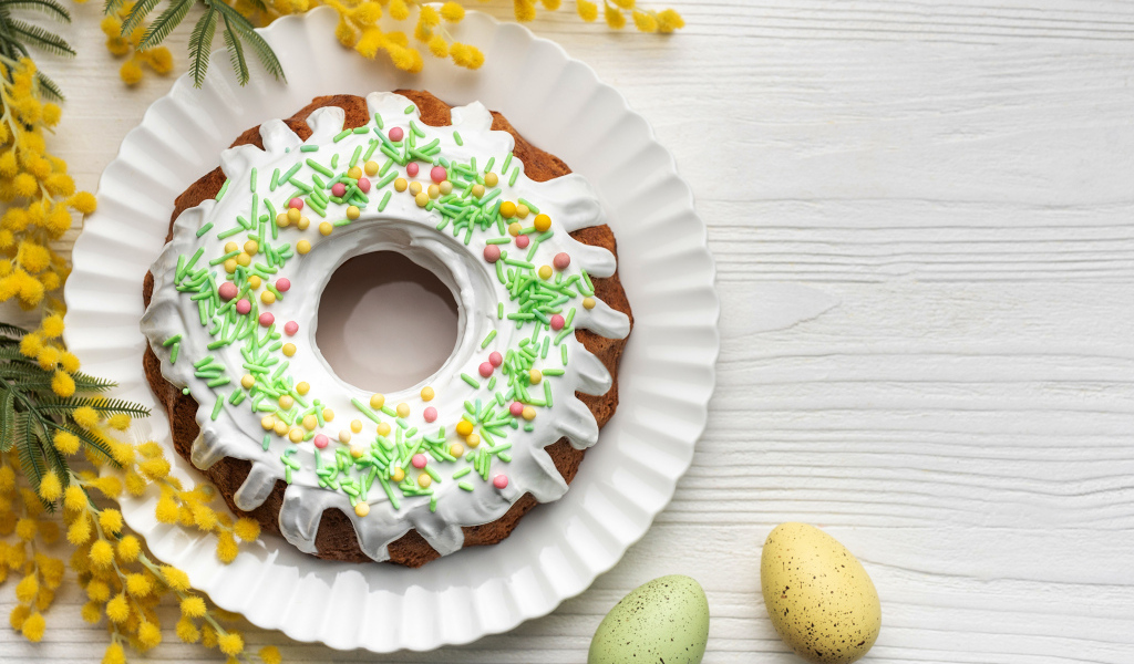 Красивый пасхальный кулич с веткой мимозы и яйцами