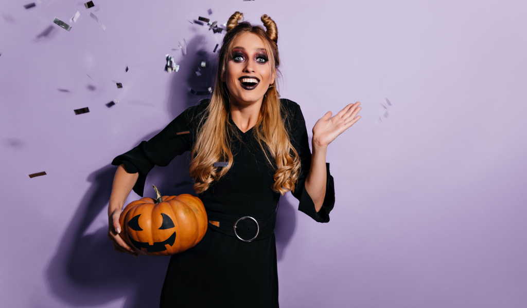 Девушка в черном костюме с тыквой на праздник Хэллоуин
