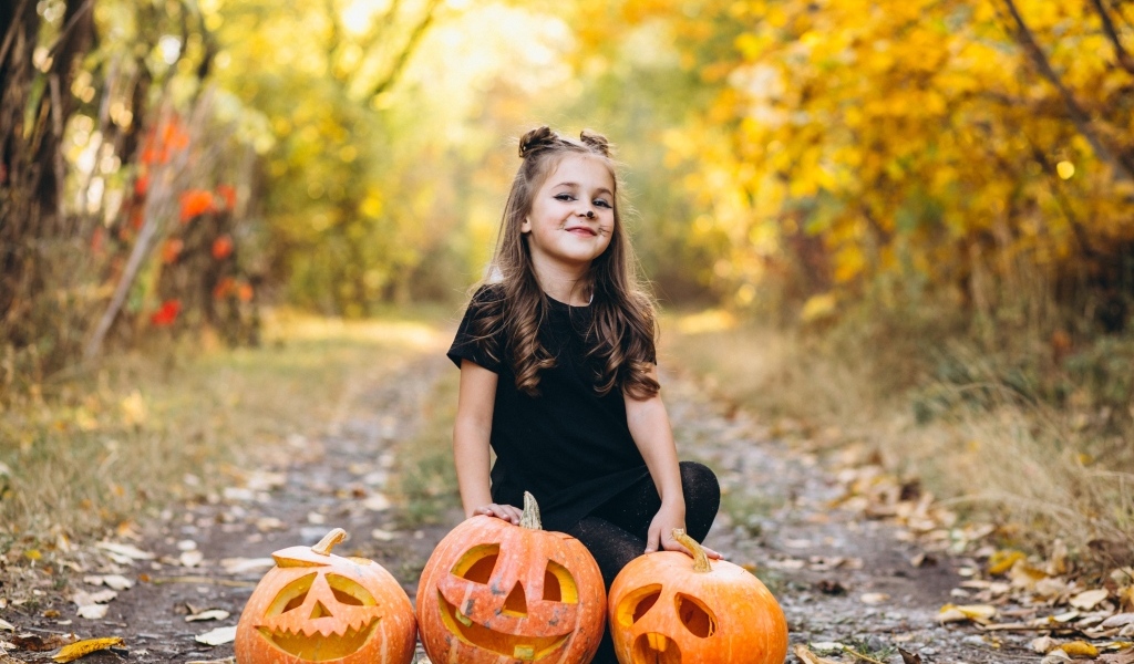 Девочка с тыквой в парке на праздник Хэллоуин