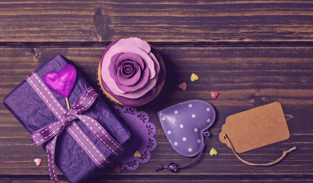 Подарок рядом с кексом, сердечком и открыткой