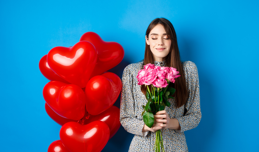 Girl with a bouquet of roses and balloons for Valentine's Day
