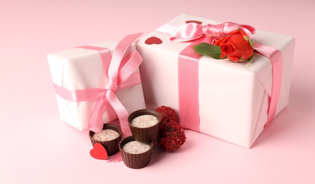Два подарка с конфетами на розовом фоне на День Святого Валентина