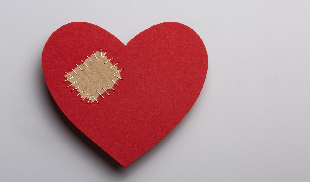 Большое красное сердце с заплаткой на сером фоне