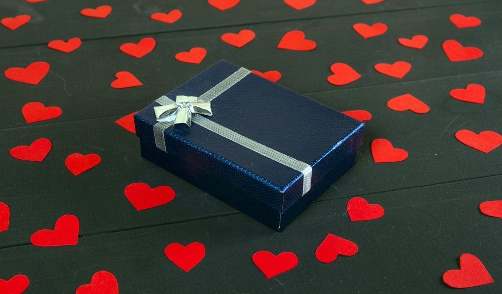 Черная коробка с красными сердечками на столе