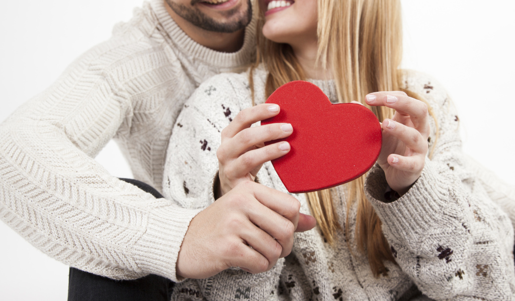Влюбленная пара с красным сердцем в руках