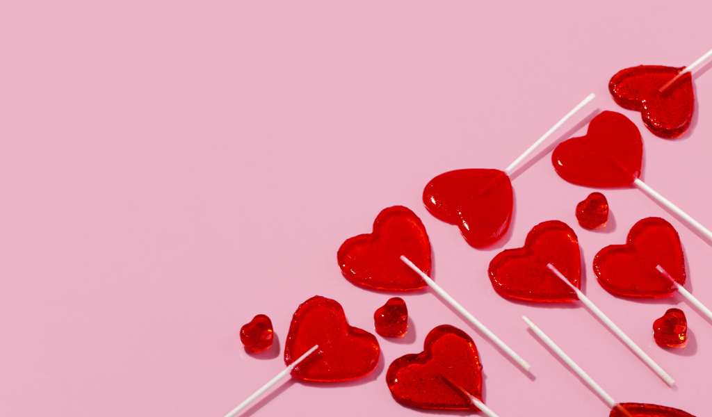 Леденцы в форме сердца на розовом фоне